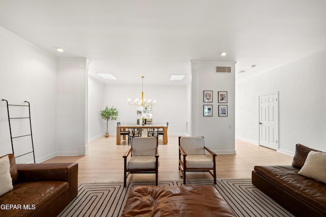 living room with light wood-type flooring, baseboards, and a notable chandelier