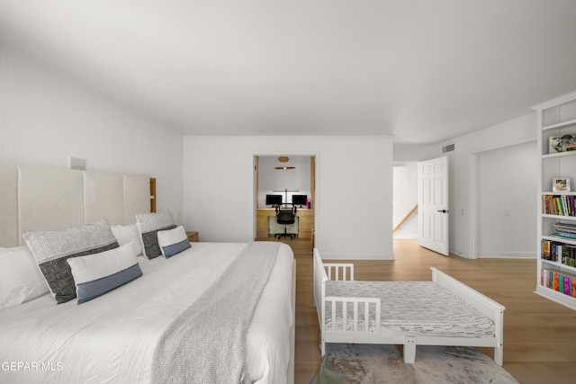 bedroom featuring wood finished floors and visible vents