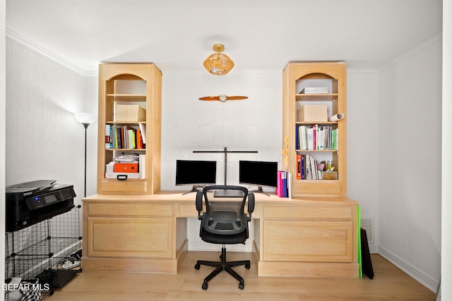 office featuring ornamental molding, built in features, light wood finished floors, and built in desk