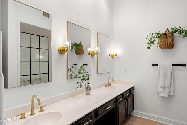 full bath with double vanity, visible vents, wood finished floors, and a sink