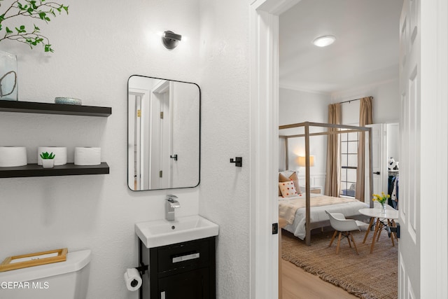 bathroom featuring ensuite bath, toilet, crown molding, and vanity