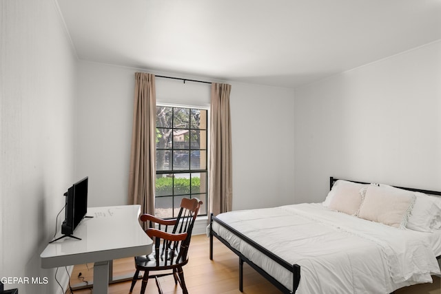 bedroom with light wood-style flooring and ornamental molding