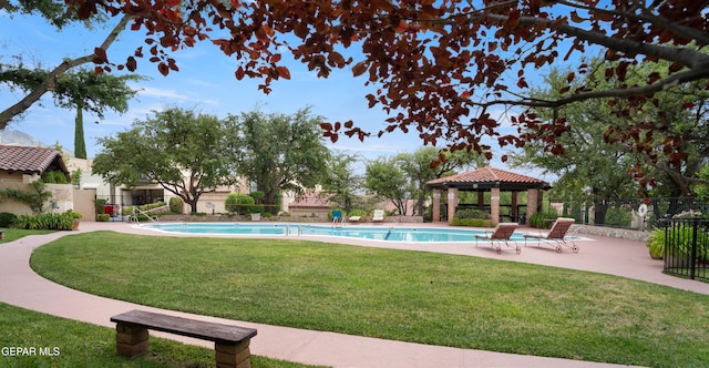 community pool featuring a lawn, a gazebo, fence, and a patio area