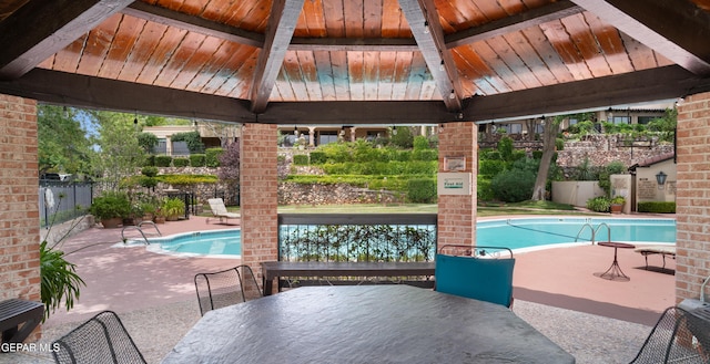 community pool with fence, a patio area, a gazebo, and outdoor dining space