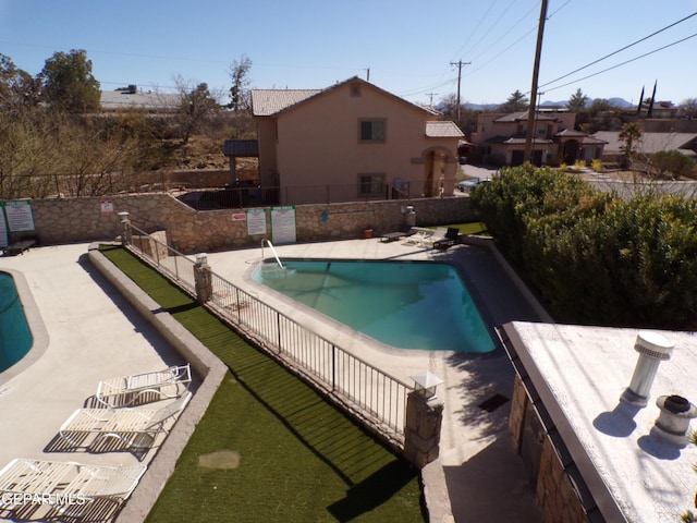 community pool featuring a patio area and fence