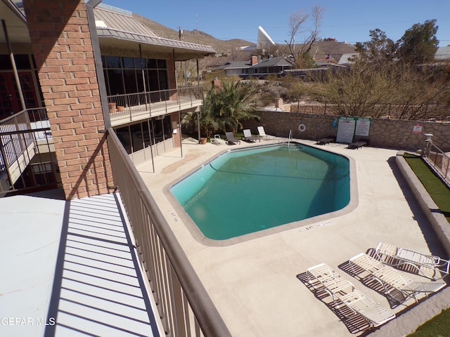 community pool featuring fence and a patio area