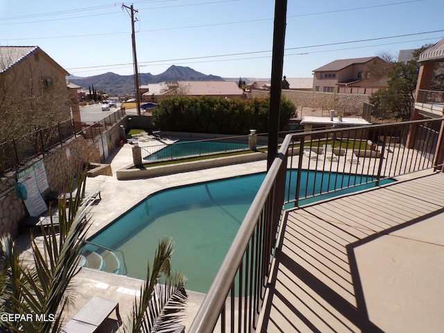 view of pool featuring fence, a patio area, a fenced in pool, and a mountain view