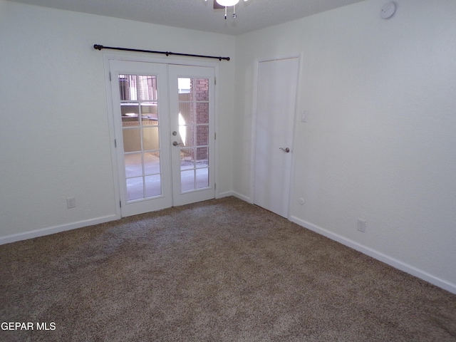 carpeted spare room with french doors, baseboards, and a ceiling fan