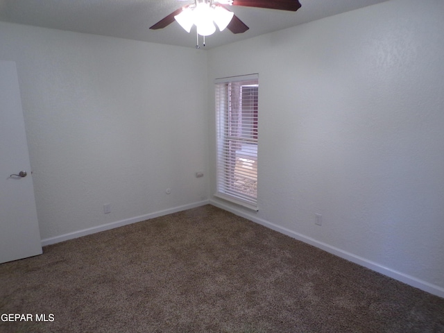 carpeted spare room with baseboards and ceiling fan