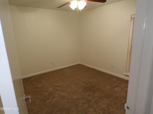 carpeted spare room featuring ceiling fan and baseboards