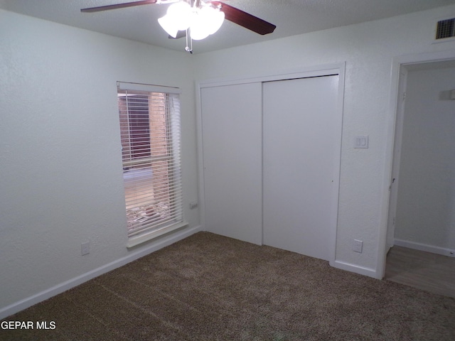 unfurnished bedroom with a ceiling fan, carpet flooring, visible vents, and a closet