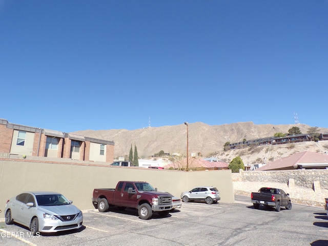 uncovered parking lot with a mountain view and fence