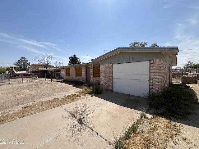 single story home with fence, brick siding, a garage, and concrete driveway