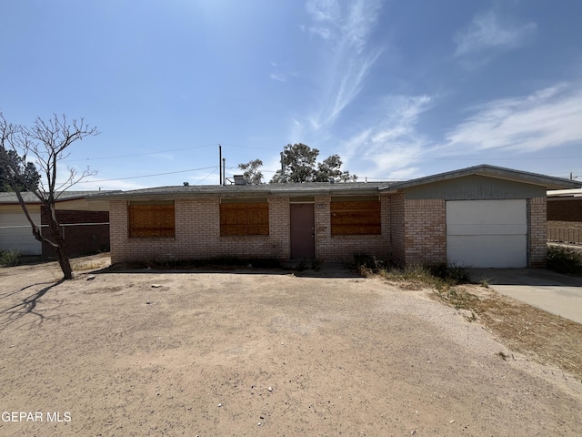 ranch-style house with concrete driveway, brick siding, fence, and a garage