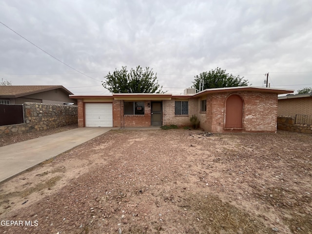single story home with brick siding, an attached garage, driveway, and fence