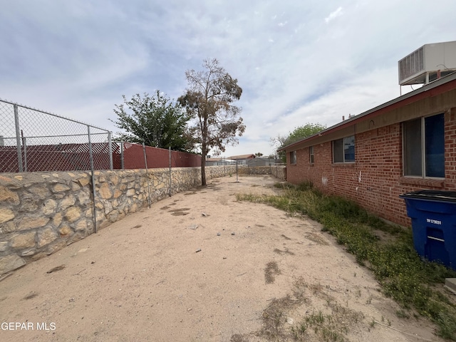 view of yard with central AC and fence