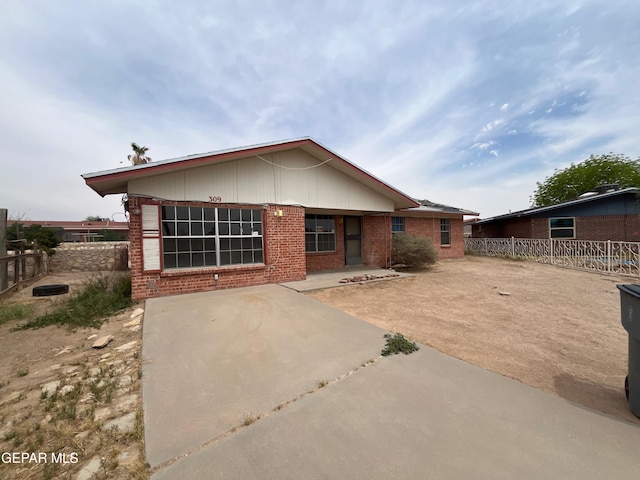back of property featuring brick siding, fence, and a patio area