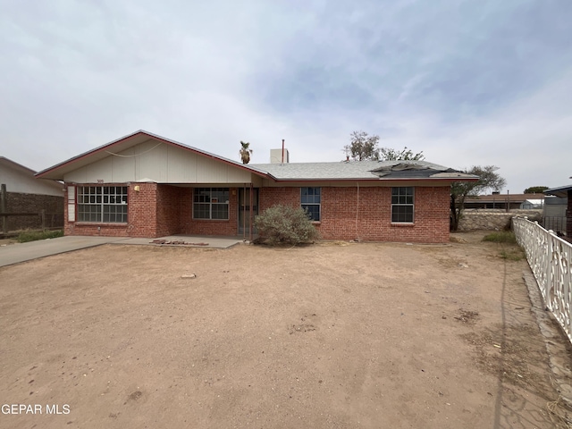 rear view of property with brick siding and fence
