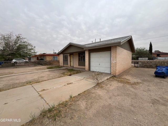 ranch-style home featuring concrete driveway, an attached garage, and brick siding