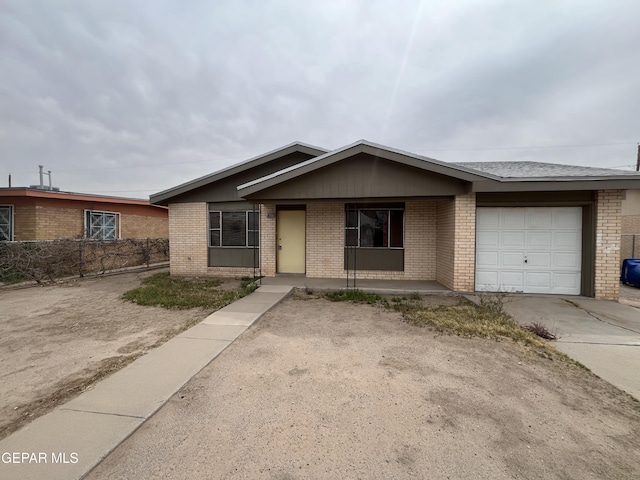 single story home featuring brick siding, an attached garage, concrete driveway, and fence
