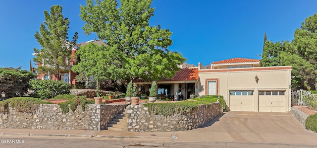 view of front of property featuring an attached garage, stucco siding, concrete driveway, and a tile roof