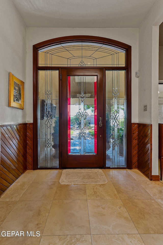 foyer entrance with wood walls and wainscoting