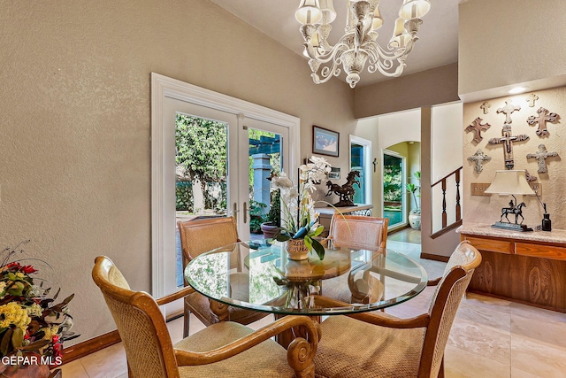dining space featuring baseboards, a textured wall, a notable chandelier, and a wealth of natural light