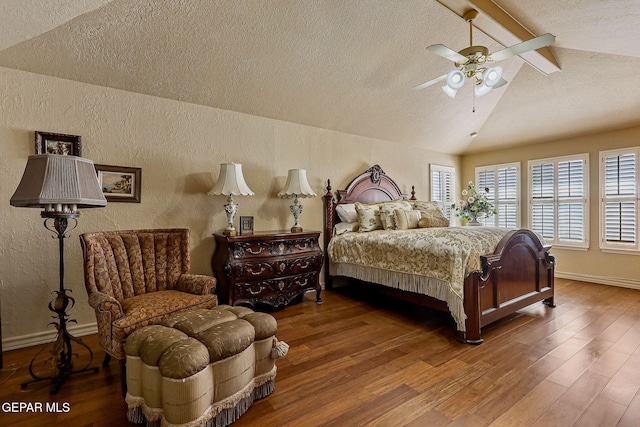 bedroom with a textured ceiling, a textured wall, lofted ceiling with beams, and wood finished floors