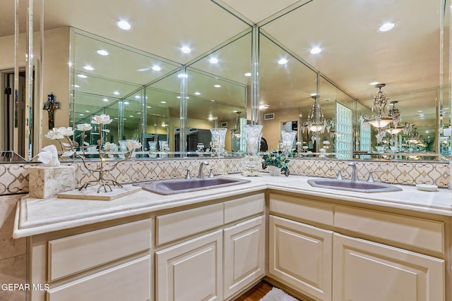 full bathroom with a sink, backsplash, and double vanity