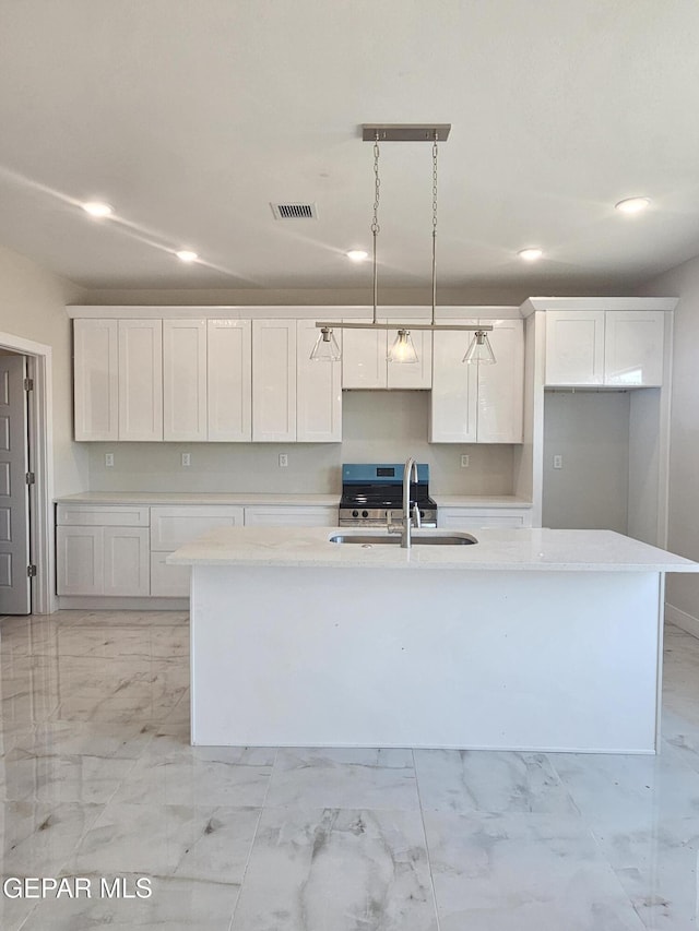 474 Sylvia Ct, Socorro, TX 79927 - kitchen with light marble finish floors, a center island with sink, recessed lighting, white cabinets, and light countertops