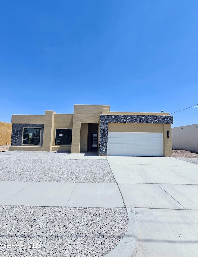 474 Sylvia Ct, Socorro, TX 79927 - view of front of house with stucco siding, an attached garage, and concrete driveway