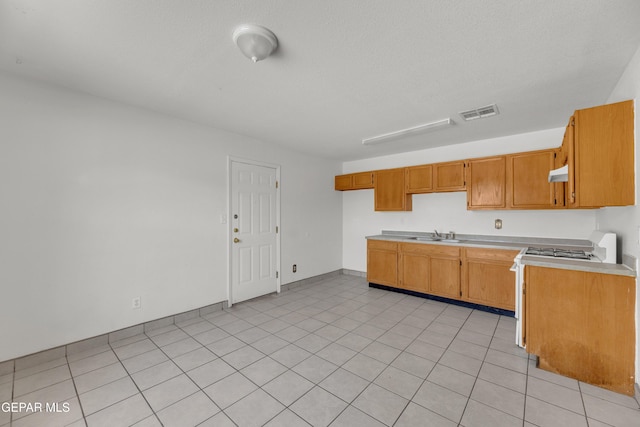 2352 Tierra Blanda Dr, El Paso, TX 79938 - kitchen with a sink, visible vents, brown cabinets, light countertops, and under cabinet range hood