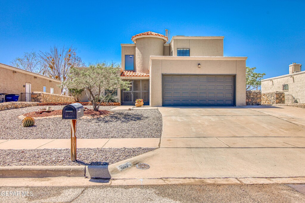 7020 Villa Hermosa Dr, El Paso, TX 79912 - view of front of home with stucco siding, an attached garage, driveway, and a tiled roof