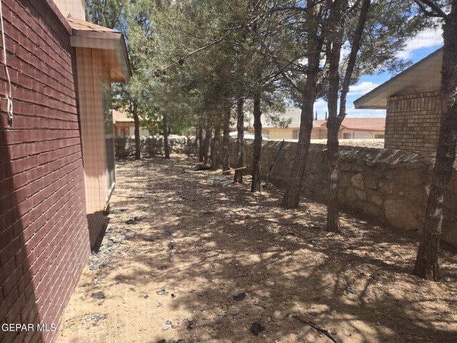 12525 Angie Bombach, El Paso, TX 79936 - view of side of home with fence and brick siding