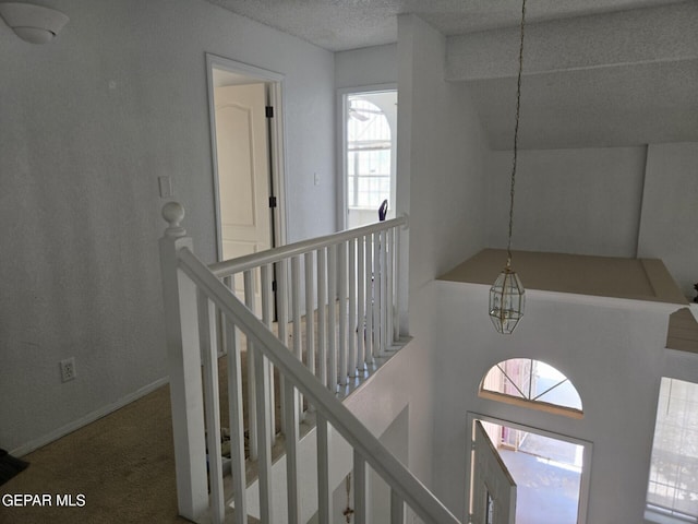 12525 Angie Bombach, El Paso, TX 79936 - hall featuring an upstairs landing, a textured ceiling, and carpet flooring