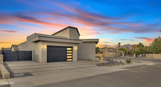 view of home's exterior featuring fence, an attached garage, driveway, and stucco siding