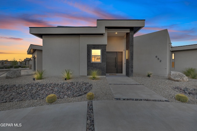 view of front of home with an attached garage and stucco siding