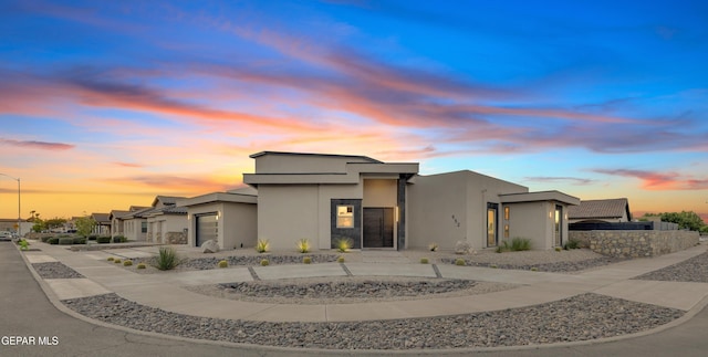 contemporary house featuring concrete driveway, a garage, and stucco siding