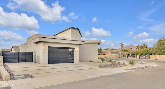 view of front facade featuring a garage, fence, stucco siding, and concrete driveway