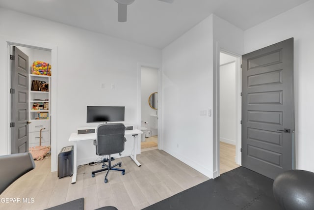 office space with baseboards, a ceiling fan, and wood finished floors