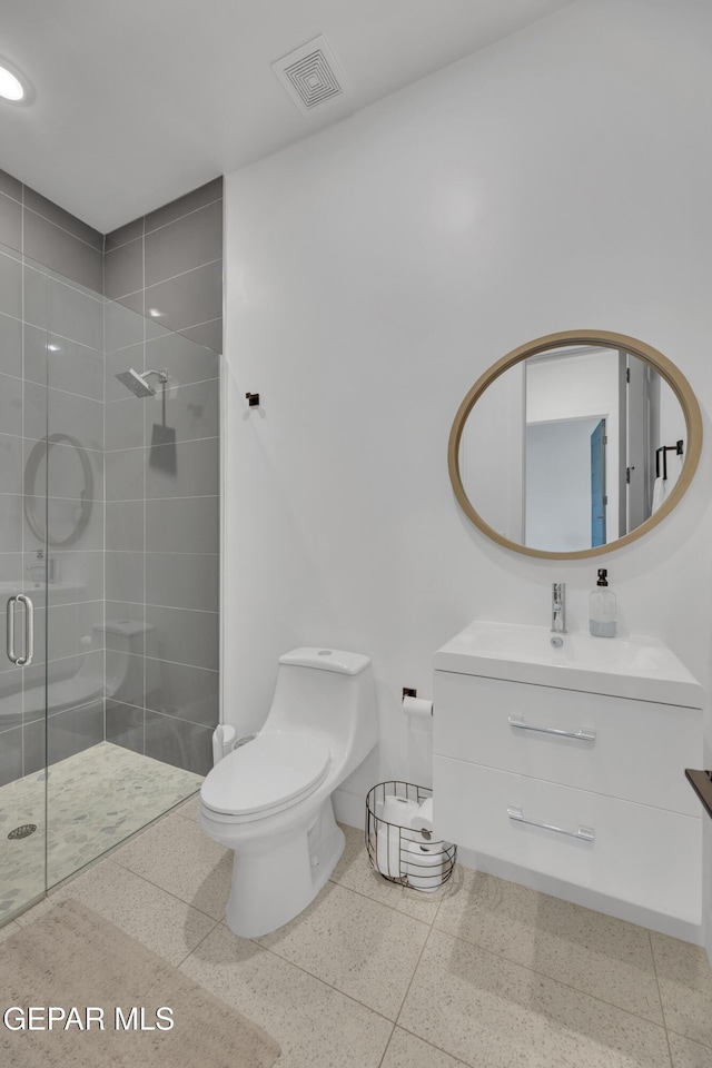 bathroom featuring visible vents, vanity, toilet, baseboards, and a stall shower