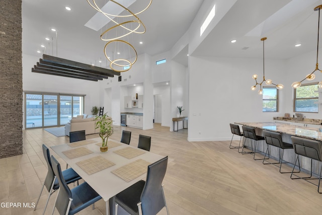 dining room featuring a high ceiling, a chandelier, and plenty of natural light