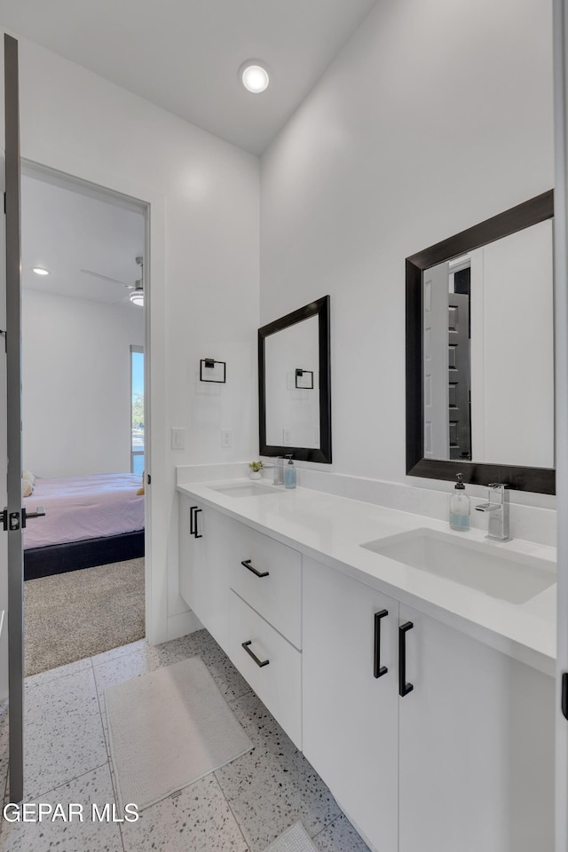 full bathroom with a sink, ensuite bathroom, double vanity, and ceiling fan