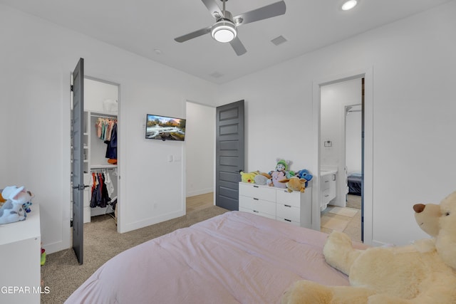 bedroom featuring a walk in closet, carpet floors, baseboards, visible vents, and a closet