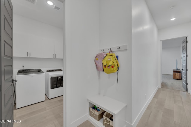 interior space with separate washer and dryer, light wood-style floors, baseboards, and visible vents