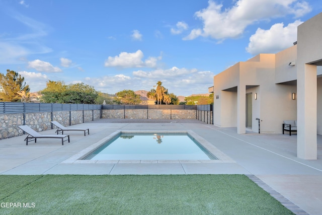 view of swimming pool featuring fence, a fenced in pool, and a patio area