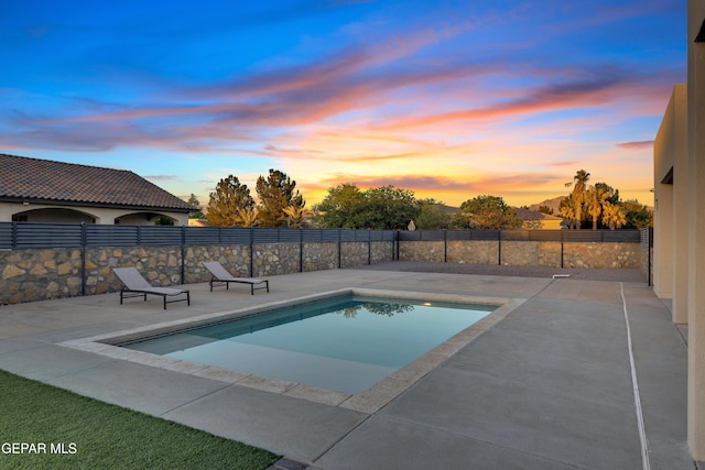 pool at dusk featuring a fenced in pool, a patio area, and fence