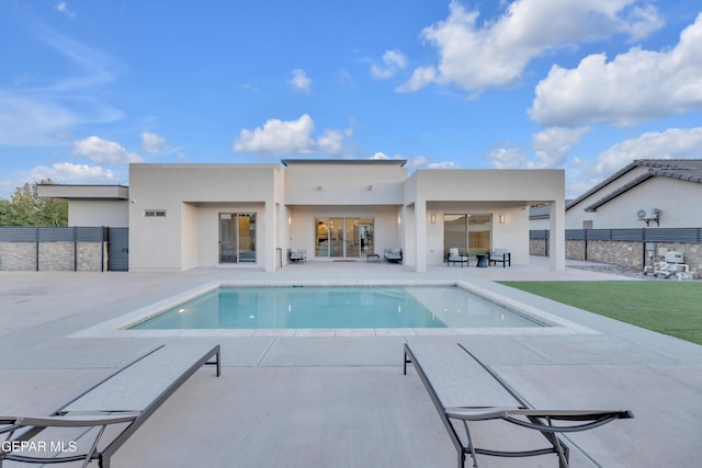 back of house with a patio, a fenced in pool, fence, and stucco siding