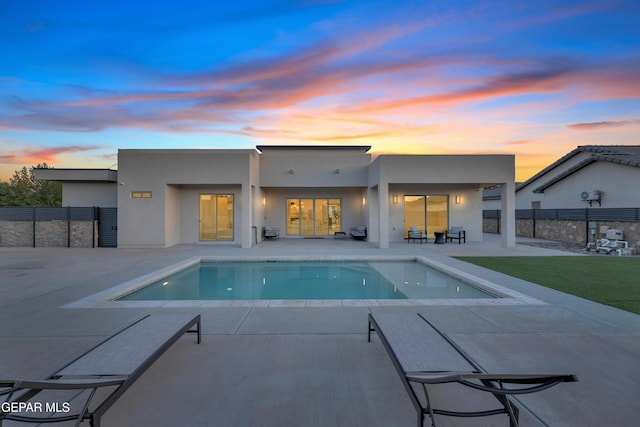 back of property with a fenced in pool, fence, a patio, and stucco siding