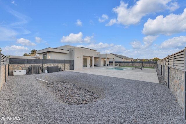 back of property featuring a fenced backyard, a fenced in pool, stucco siding, and a patio area